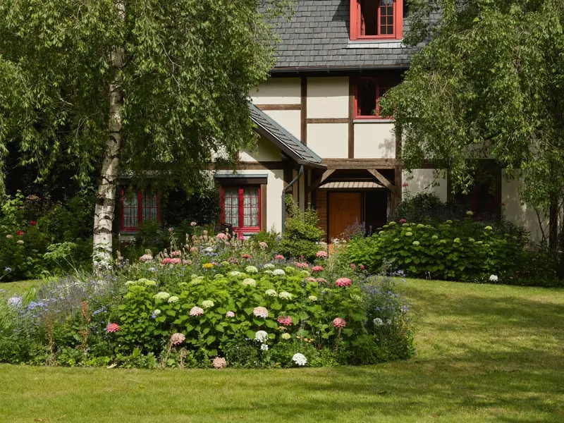Fachwerkhaus mit blühendem Garten und Birken