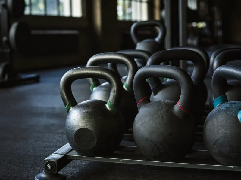 Schwarze Kettlebells auf einem Gestell im Studio